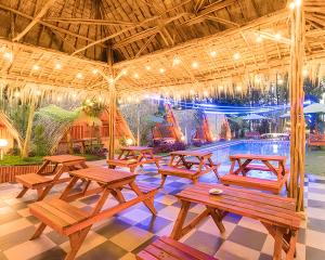 een groep picknicktafels in een paviljoen met een zwembad bij New DGYP Ciater Resort in Ciater