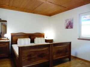 um quarto com uma cama de madeira e uma janela em Ferienhaus Vollmer em Nordrach