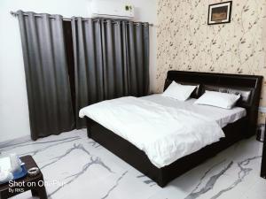 a bedroom with a large bed with black curtains at Osho home in Lucknow