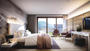 a bedroom with a bed and a desk with chairs at Leni Mountain Lodge in Sölden