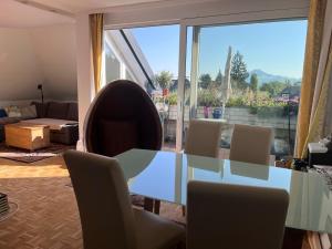 une salle à manger avec une table et des chaises en verre dans l'établissement Ruhiges Apartment mit Dachterrasse in Salzburg, à Salzbourg