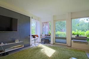 ein Wohnzimmer mit einem Flachbildfernseher und einem Tisch und Stühlen in der Unterkunft Ruhiges & gemütliches Apartment im Herzen von Hüde 300 m entfernt vom Dümmer See in Hüde