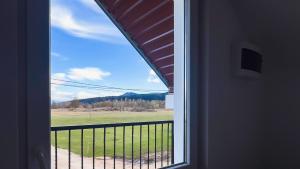 a window view of a field from a house at Seoski kutak Piva in Plužine