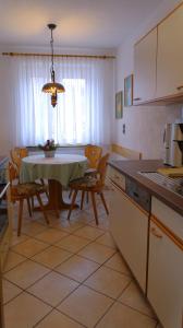 eine Küche und ein Esszimmer mit einem Tisch und Stühlen in der Unterkunft Appartment-Haus Janine in Westendorf