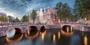 een brug over een rivier in een stad met gebouwen bij Groot vakantiehuis nabij Amsterdam inclusief jacuzzi in Zeewolde