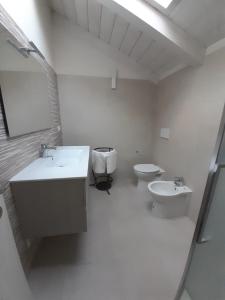 een badkamer met 2 toiletten, een wastafel en een toilet. bij CASA LAVANDA in Rivoli