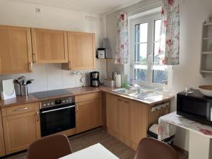 a kitchen with wooden cabinets and a sink and a window at Haus Betty in Rattelsdorf