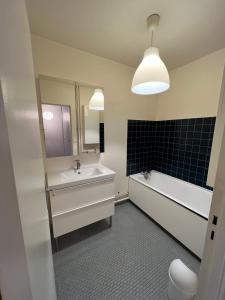 a bathroom with a sink and a tub and a toilet at Appartement lumineux 2 pièces Paris – idéal famille in Paris