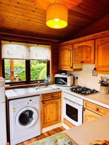 a kitchen with a washer and a stove top oven at 'Mallard' Secluded Rustic Lodge - Digital Detox Paradise in Allerthorpe