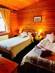 a bedroom with two beds in a log cabin at 'Mallard' Secluded Rustic Lodge - Digital Detox Paradise in Allerthorpe