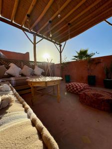 a patio with a table and a couch at Riad Sanwa in Marrakesh