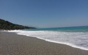 a beach with a few people walking in the water at AGATHA appartments PALIOURIA in Kókkinon Nerón