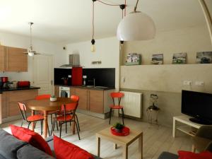 ein Wohnzimmer mit einem Sofa und einem Tisch mit roten Stühlen in der Unterkunft LOFT au cœur de Bécherel in Bécherel