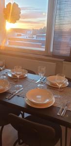 罗瓦涅米Arctic Condo at City Centre的一张桌子,上面放有盘子和酒杯,还有一个窗口