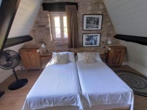 una camera da letto con letto bianco in mansarda di Les Bernardies a Simeyrols