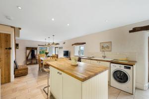 a kitchen and living room with a washer and dryer at Host & Stay - The Barn - Upper Farm in Tideswell