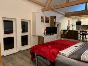 a bedroom with a bed with a red blanket at Ferienwohnung Schwein gehabt in Allna