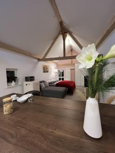a living room with a couch and a vase with flowers at Ferienwohnung Schwein gehabt in Allna
