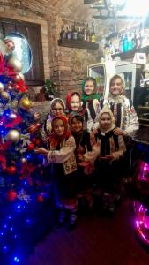 grupa dzieci pozujących obok choinki świątecznej w obiekcie Casa Domnească Rarau w mieście Kimpulung Mołdawski