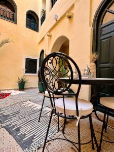 a chair sitting at a table in a patio at Riad Sanwa in Marrakesh