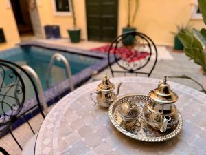 a table with two tea pots and a plate on it at Riad Sanwa in Marrakesh