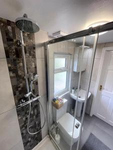 uma casa de banho com um chuveiro e um lavatório. em 1 Bed Attic Flat with Easy Reach to City Centre em Londres