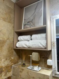 un baño con un estante con toallas. en Florilor Residence I en Piteşti