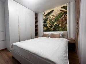 ピテシュティにあるFlorilor Residence Iのベッドルーム1室(壁に絵画が描かれた大型ベッド1台付)
