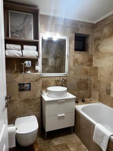 a bathroom with a sink and a tub and a toilet at Florilor Residence I in Piteşti
