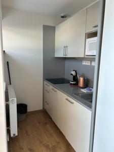 a kitchen with white cabinets and a black counter top at apartmán Oblík - penzion Kilián in Kvilda
