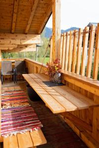 eine Holzbank auf der Veranda einer Hütte in der Unterkunft Erlenhof in Maria Alm am Steinernen Meer