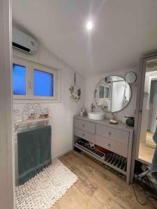 a bathroom with a sink and a mirror at Le Clos des Anges, adorable Penty bord de mer in Séné