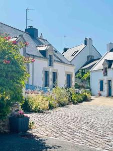 a group of white houses on a brick street at Le Clos des Anges, adorable Penty bord de mer in Séné