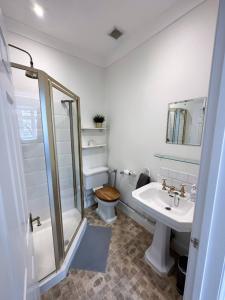 a bathroom with a shower and a toilet and a sink at Homestay - En-suites in New Malden