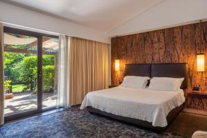 a bedroom with a bed and a large window at Vallegrande Nature Resort by Geocharme in Cefalù