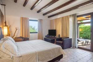 a bedroom with a bed and a living room at Vallegrande Nature Resort by Geocharme in Cefalù