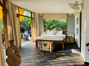 a bedroom with a bed and a large window at Casa Da Praia in Candolim