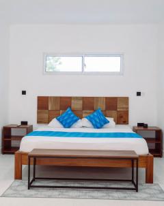 a bedroom with a large bed with blue pillows at Trio Villas Watamu in Watamu