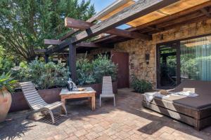 a patio with a bed and two chairs and a table at Vallegrande Nature Resort by Geocharme in Cefalù