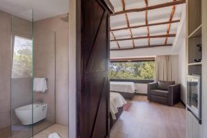 a bathroom with a bedroom with a bed and a window at Vallegrande Nature Resort by Geocharme in Cefalù