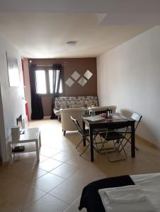 een woonkamer met een tafel en een bank bij Apartaments ENGAIT in Pas de la Casa
