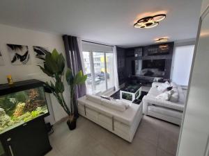 a living room with a fish tank and a couch at Appartement neuf moderne + parking, Genève in Saint-Genis-Pouilly