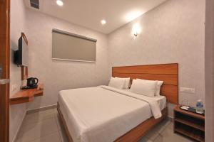 a bedroom with a bed and a flat screen tv at CR RIVERA in Madurai