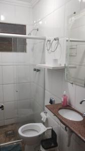 a white bathroom with a toilet and a sink at HOSTEL VENDA NOVA in Belo Horizonte