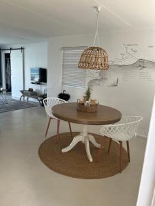 a dining room table with chairs and a chandelier at TAKE TWO lovely beach apartment, Great Brak River in Great Brak River
