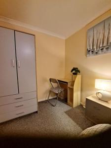 a room with a desk and a dresser and a desk with a chair at Room in Essex in Pitsea