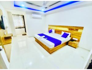 a bedroom with a bed with blue pillows at Hotel Paradise, Naroda in Ahmedabad