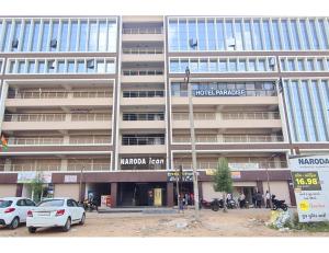 a large building with cars parked in front of it at Hotel Paradise, Naroda in Ahmedabad