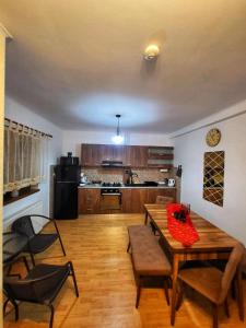 uma sala de estar com uma mesa de madeira e uma cozinha em La Simo em Sinaia