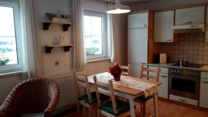 uma cozinha com uma mesa de madeira com cadeiras e uma mesa e uma mesa e cadeiras em Ferienhaus Plessberg 